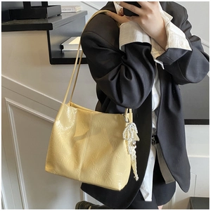 Détail du sac cabas en cuir plissé jaune pâle avec breloque cœur en perles