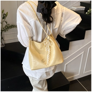 Détail d'un sac cabas en cuir jaune plissé avec accessoire élégant en dentelle et perles
