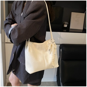 Détail du sac fourre-tout plissé blanc cassé avec nœud en dentelle de perles et breloque