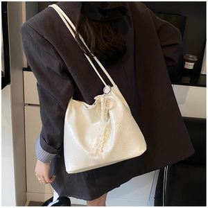 Détail du sac à bandoulière ivoire plissé brillant avec breloque perle et dentelle