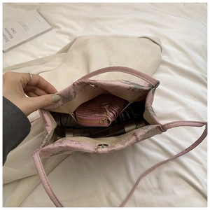 Vista dell'interno della borsa a secchiello rosa ricamata con spazio per ombrello e portafoglio
