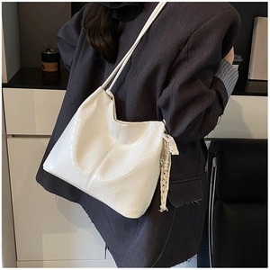 Vue détaillée du sac seau blanc gaufré avec pendentif en perles et dentelle et lanières