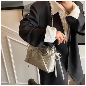 Detail of silver balletcore shoulder bag with oversized bow and pearl ribbon charms