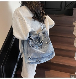 Bolso tote de mezclilla azul con dos bolsillos delanteros y botones de metal