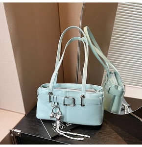 Dettaglio borsa a secchiello blu menta con ciondolo a fiocco argento e corda intrecciata