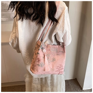 Dettaglio borsa a spalla in seta rosa con ricamo cinese e nappine decorative