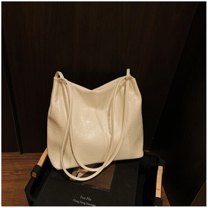 Gros plan sur la texture froissée et la bandoulière de ce sac seau blanc cassé chic