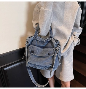 Detailaufnahme der dunkelblauen Denim-Tragetasche mit Kordelzug und Vordertasche