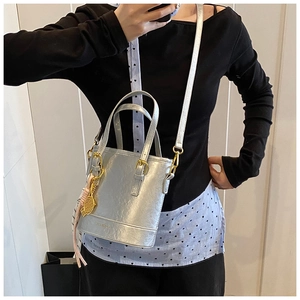 Detail of silver bucket bag with gold-tone hardware and tennis racket pendant