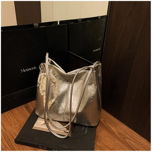 Détail du sac cabas argenté avec texture métallique froissée et breloque en perles