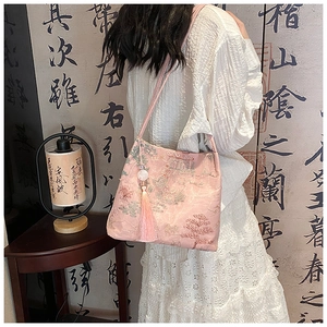 Dettaglio della borsa a secchiello in jacquard rosa con motivi paesaggistici e nappe