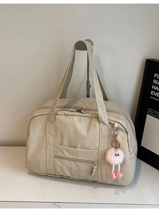 Large beige canvas travel bag with top zipper and plush charm for women commute