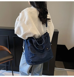 Detalle de bolso tote de mezclilla azul oscuro con cordón y bolsillo frontal grande en modelo