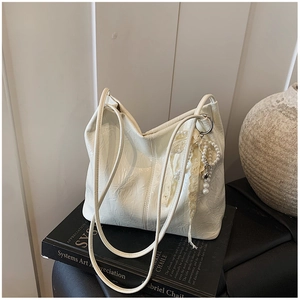 Vue détaillée d'un sac seau en cuir plissé blanc orné de perles élégantes et de dentelle