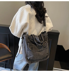 Detalle de bolso tote denim gris con bolsillo de presión y correa ajustable