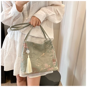 Dettaglio della borsa tote in broccato verde con ricamo tradizionale di paesaggi cinesi
