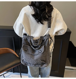 Detalle del bolso bandolera de mezclilla gris con bolsillo frontal y cordón ajustable