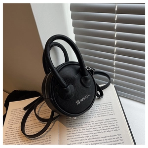 Detail of black mini round handbag with lychee pattern leather and adjustable strap