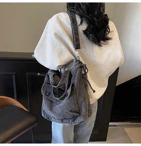 Detailansicht der großen anthrazitfarbenen Denim-Tasche mit Kordelzug und Tasche am Modell