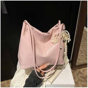 Détail du sac cabas plissé rose brillant avec breloque cœur en perles et dentelle
