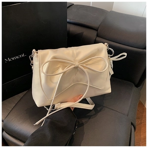 Close-up of cream bow-knot shoulder bag featuring premium PU texture and silver hardware