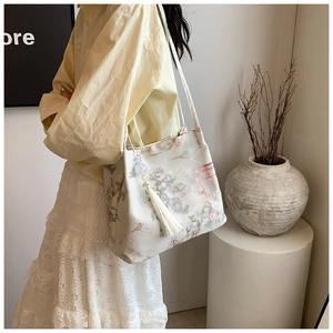 Detailed view of Chinese style bucket bag with landscape pattern and tassel charm