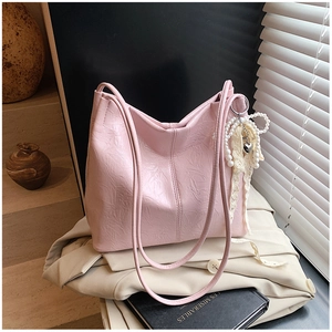 Détail du sac cabas plissé rose avec breloque en perles et dentelle et pendentif cœur