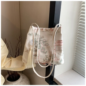 Dettaglio del ricamo in stile cinese su una borsa a secchiello in tela color beige