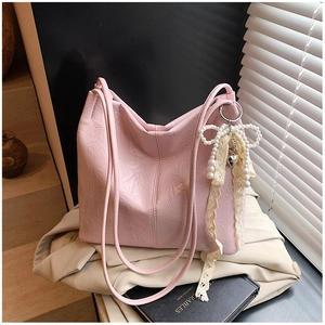 Détail du sac cabas plissé rose avec nœud perlé, ruban dentelle et pendentif cœur