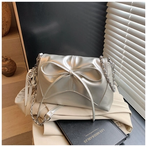 Detail of silver bow shoulder bag with metallic PU finish and elegant silk ribbon