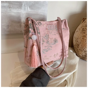 Dettaglio del ricamo tradizionale cinese e della nappa rosa sulla borsa a secchiello