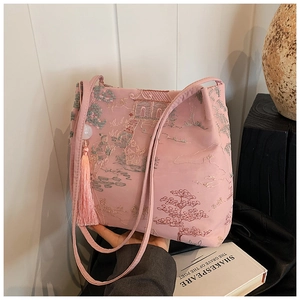Dettaglio borsa a secchiello in raso rosa con ricami cinesi e nappina lunga