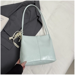 Détail du sac seau vert menthe avec texture froissée et breloque en perle dentelle