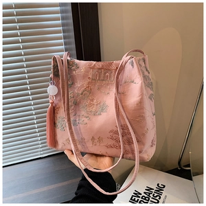Dettaglio borsa a secchiello rosa con ricamo cinese tradizionale e nappa decorativa