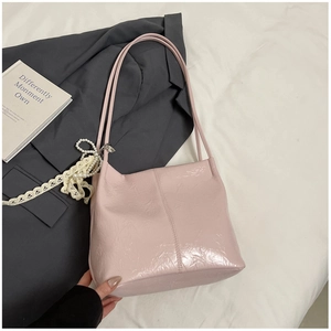Détail du sac cabas rose effet froissé avec pendentif en perles et nœud en dentelle