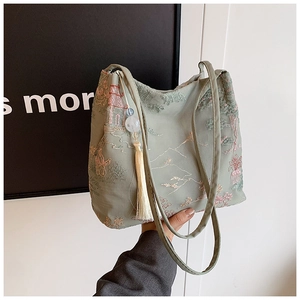 Ricamo dettagliato di paesaggi cinesi e nappa bianca su una borsa tote in colore verde chiaro