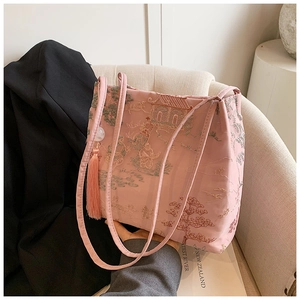 Dettaglio della borsa in raso rosa con ricamo di giardino cinese tradizionale e nappa