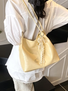 Sac cabas plissé jaune clair avec breloque perle et dentelle porté par un mannequin