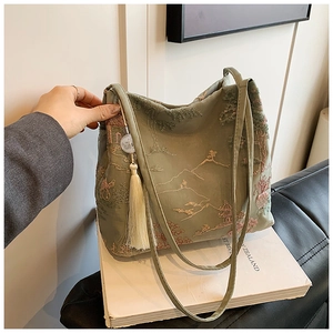 Ricamo dettagliato di paesaggi cinesi su una borsa a secchiello in tessuto verde con nappe