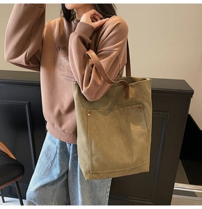Bolso tote de lona verde oliva con asas de cuero, mostrado en modelo para uso casual