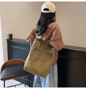 Detalle del bolso tote grande de lona con correas de cuero y remaches metálicos