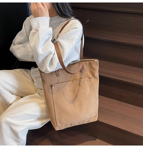 Primer plano de bolso tote de lona con asas de cuero en escalera de madera