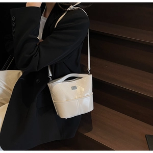 Dettaglio borsa a secchiello trapuntata crema con tracolla a catena e logo ELLE