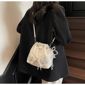 Vue détaillée du sac seau crème avec nœud en perles et poches latérales