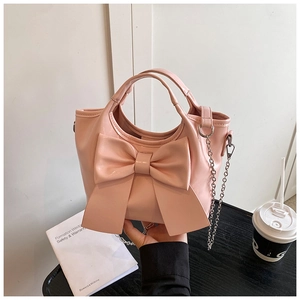 Detail der rosa PU-Leder Beuteltasche mit großer Schleife und silbernem Kettenriemen