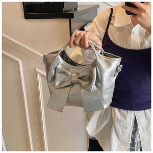 Detailansicht der silbernen Beuteltasche mit großer Schleife und Metallic Lederstruktur