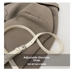 Détail d'une bandoulière réglable en similicuir crème avec boucle en métal argenté