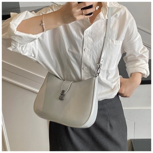 Fashionable light gray glossy leather crossbody bag with metal buckle shown on model