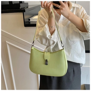 Detailed side view of a minimalist light green crescent underarm bag on a model