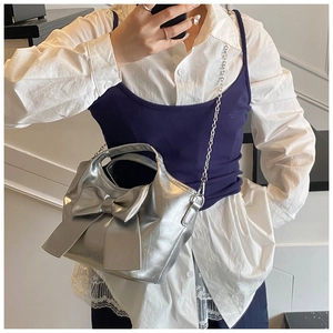 Detailansicht der silbernen Metallic-Eimertasche mit großer Schleife und Kette